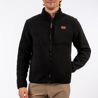 Man wearing a black jacket with a brown patch on a white background