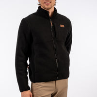 Man wearing a black jacket with a brand logo on a white background