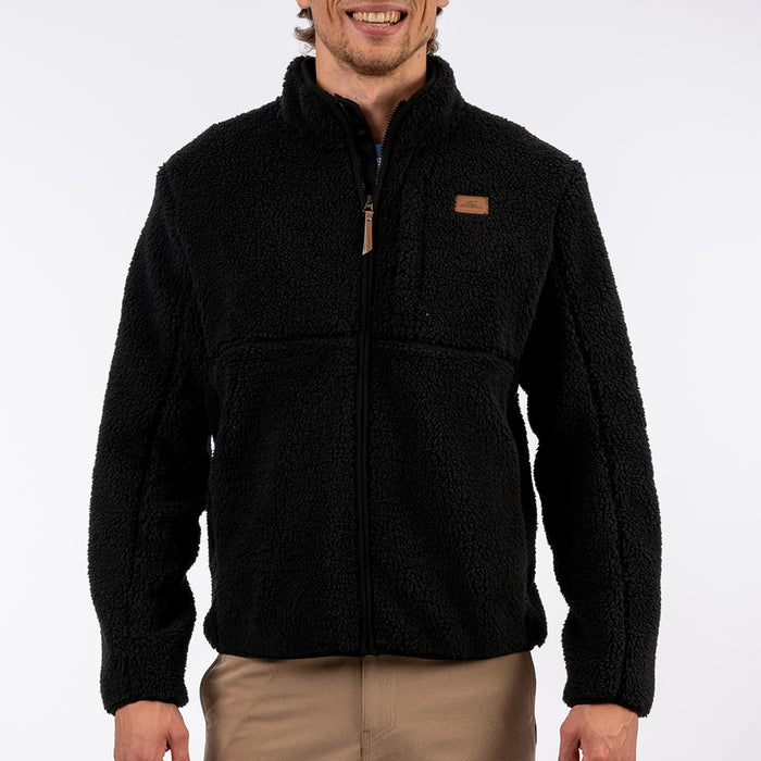 Man wearing a black fleece jacket with a brand logo on a white background
