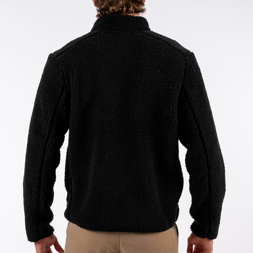 Person wearing a black fleece jacket on a white background