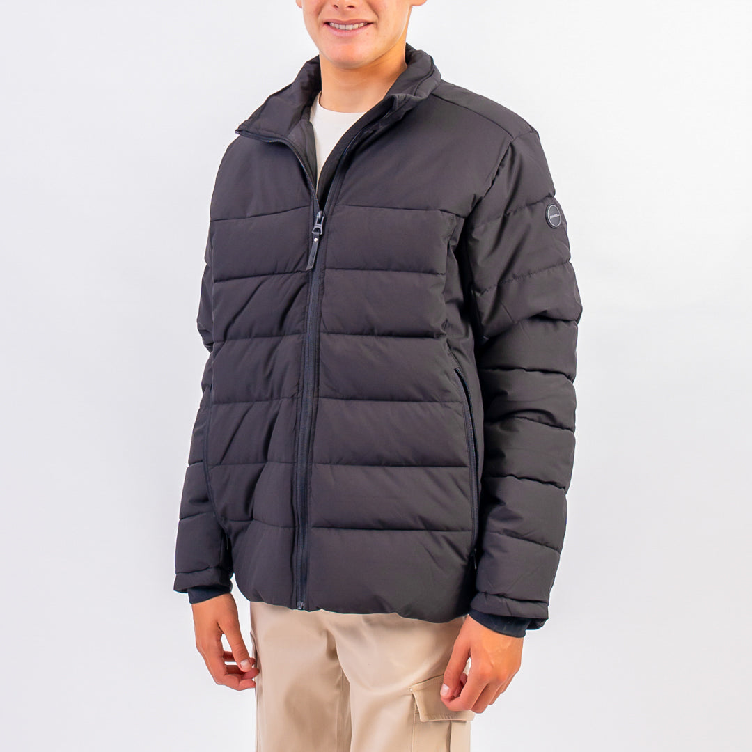 Person wearing a dark gray puffer jacket on a white background