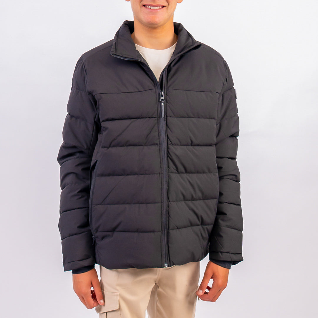 Person wearing a black puffer jacket on a white background