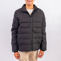 Person wearing a black puffer jacket on a white background