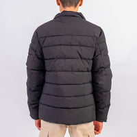 Black puffer jacket worn by a person on a light gray background