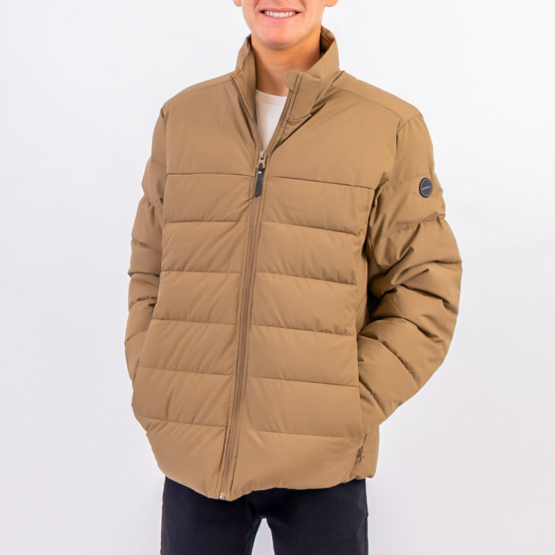 Person wearing a brown puffer jacket on a white background