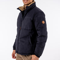 Man wearing a dark blue jacket with a fur-lined hood on a white background