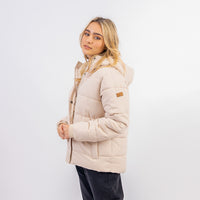 Woman wearing a beige puffer jacket on a white background