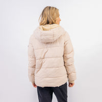 Person wearing a beige puffer jacket with a hood on a white background