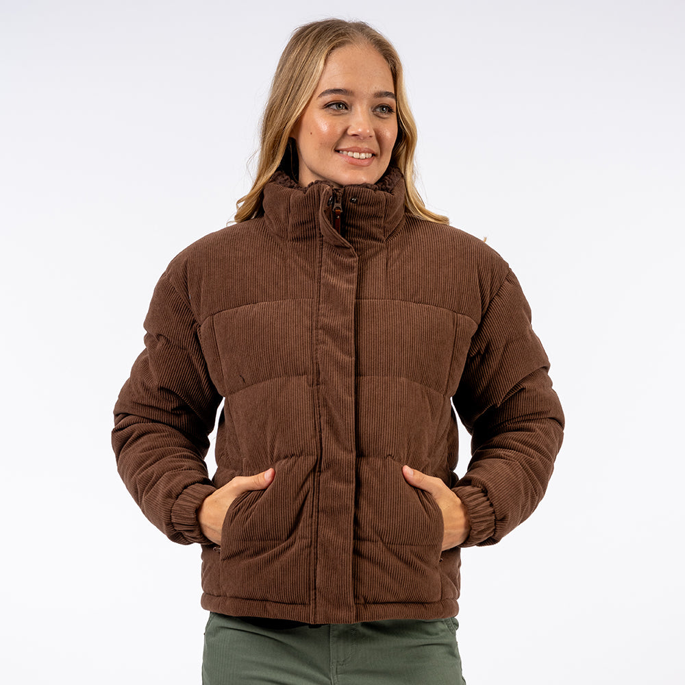 Woman wearing a brown quilted jacket on a white background