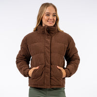 Woman wearing a brown quilted jacket on a white background