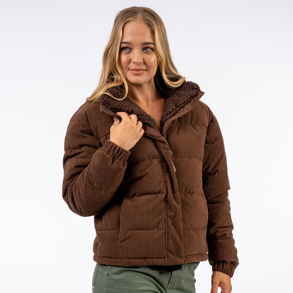 Woman wearing a brown puffer jacket on a white background
