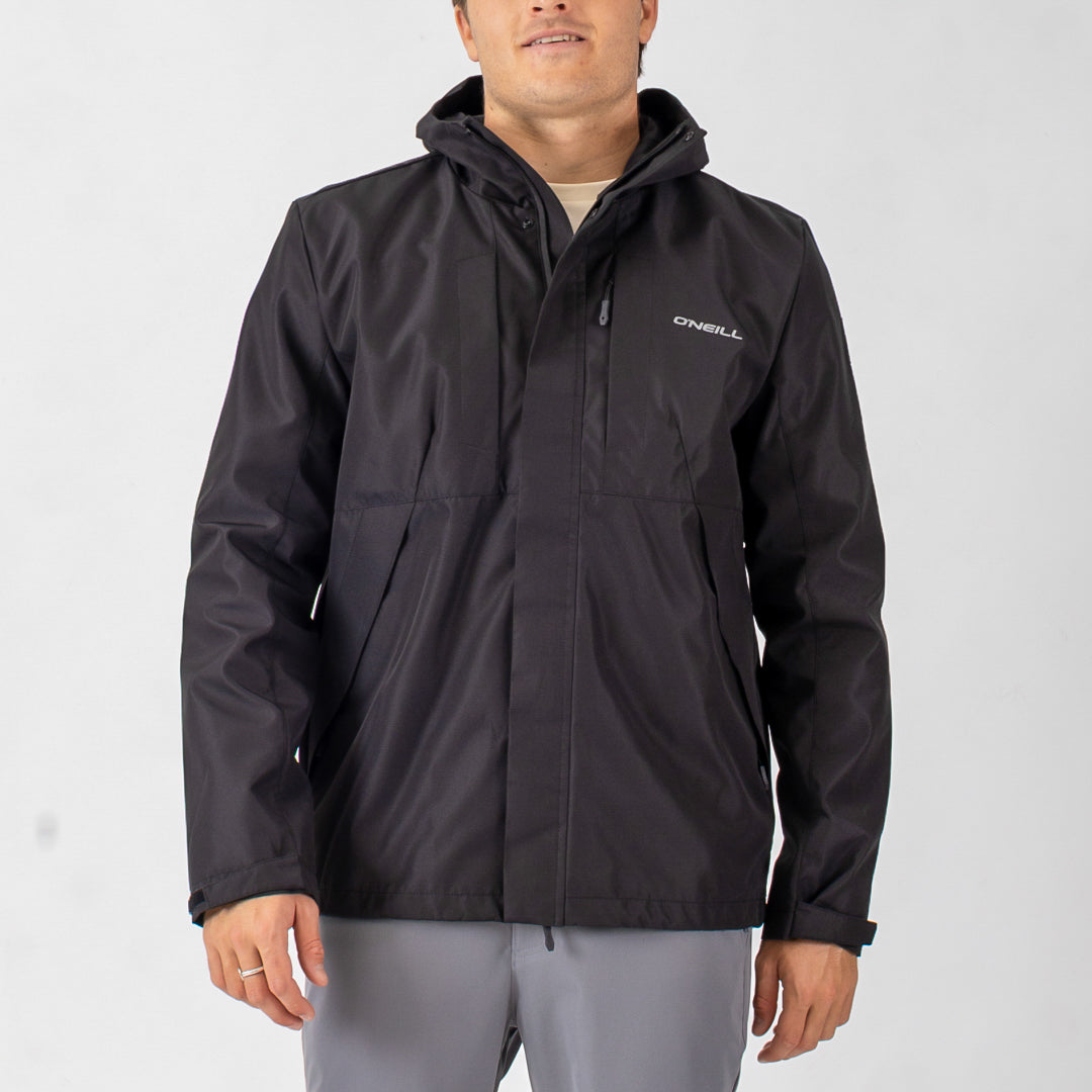 Person wearing a black jacket with a visible brand logo on a light gray background