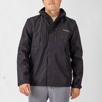 Person wearing a black jacket with a visible brand logo on a light gray background