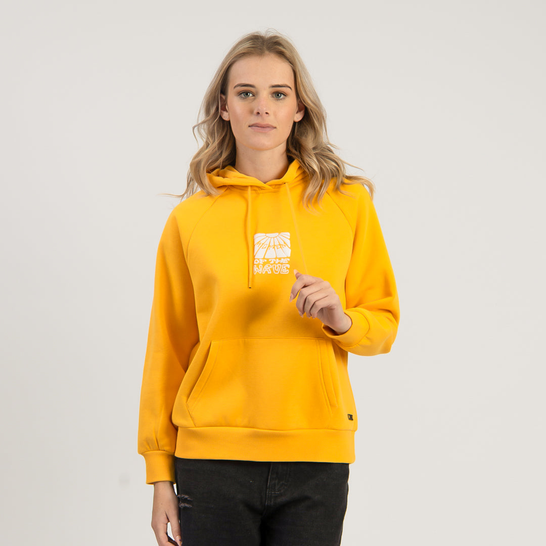 Person wearing a yellow hoodie with a logo on a plain background
