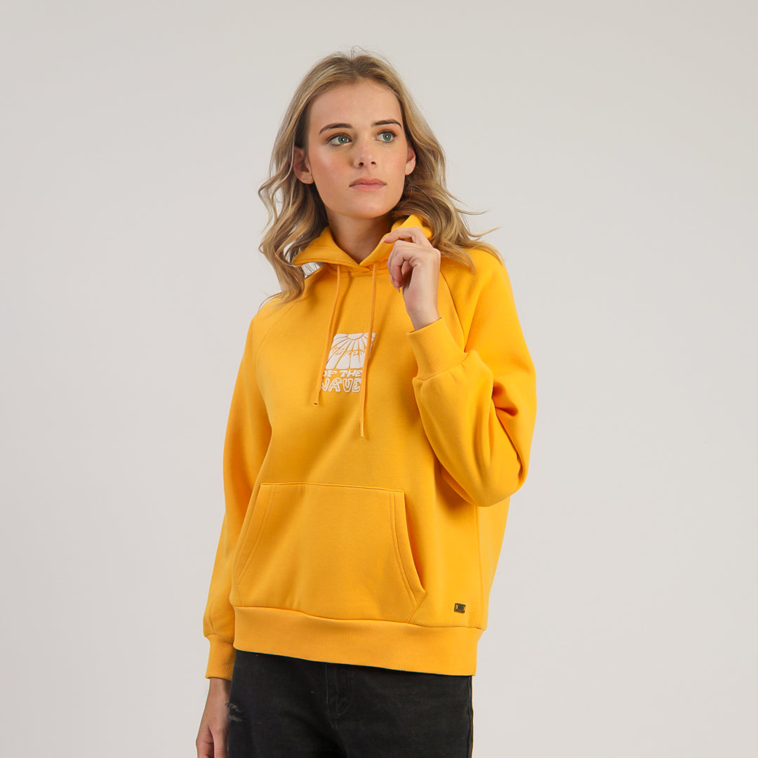 Person wearing a yellow hoodie on a plain background