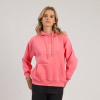 Person wearing a pink hoodie with yellow text on a plain background