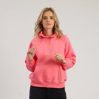 Person wearing a pink hoodie with a logo on a plain background