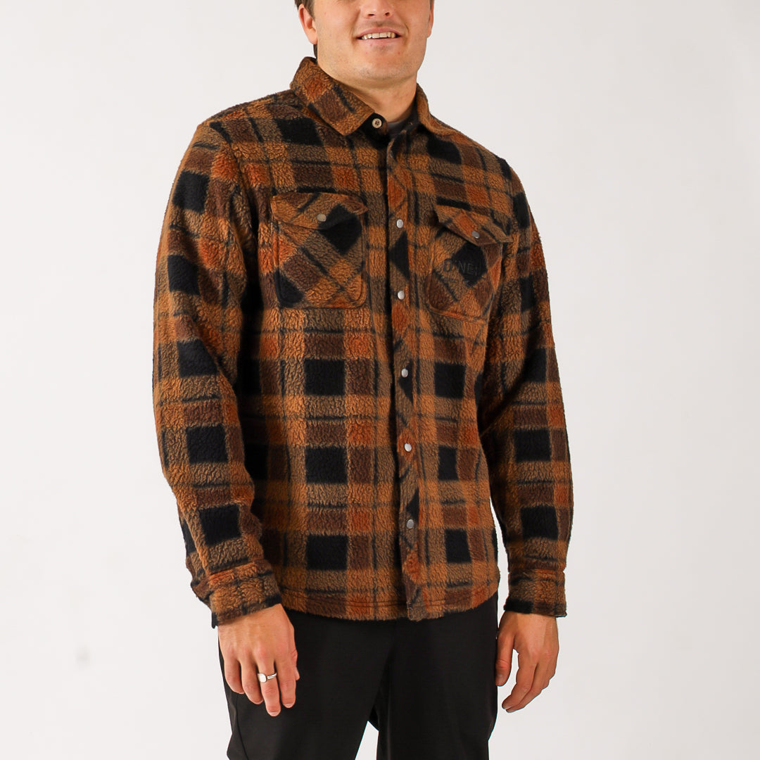 Man wearing a brown and black plaid shirt on a white background