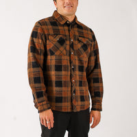 Man wearing a brown and black plaid shirt on a white background