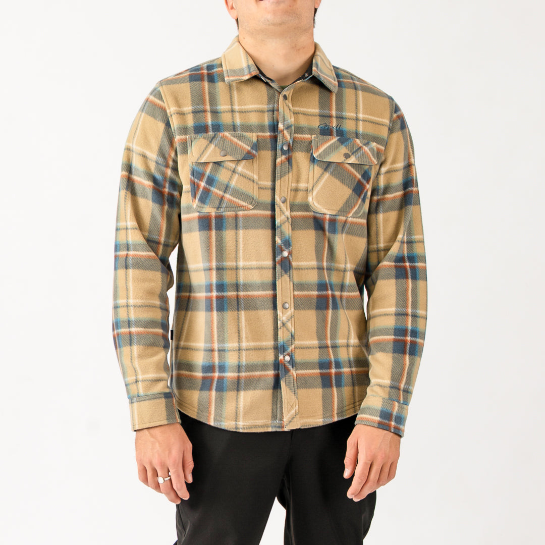 Person wearing a plaid shirt with a neutral color palette on a white background