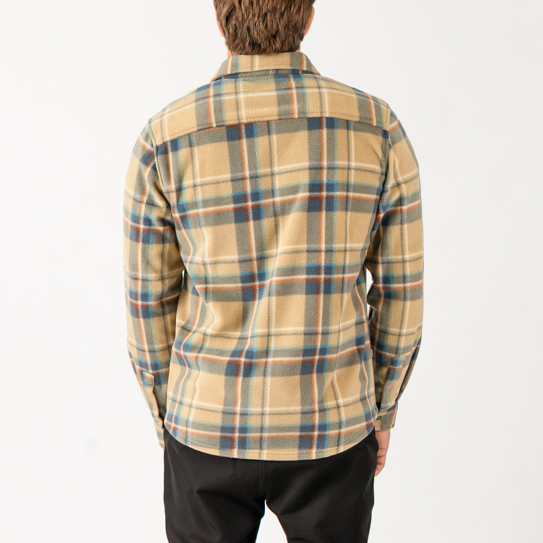 Person wearing a plaid shirt with a neutral background
