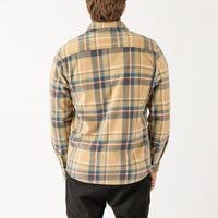 Person wearing a plaid shirt with a neutral background