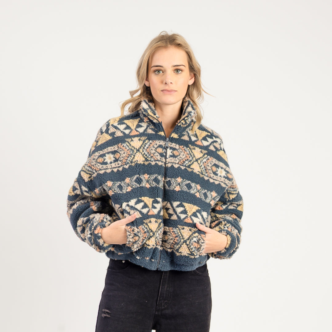 Woman wearing a patterned jacket on a white background