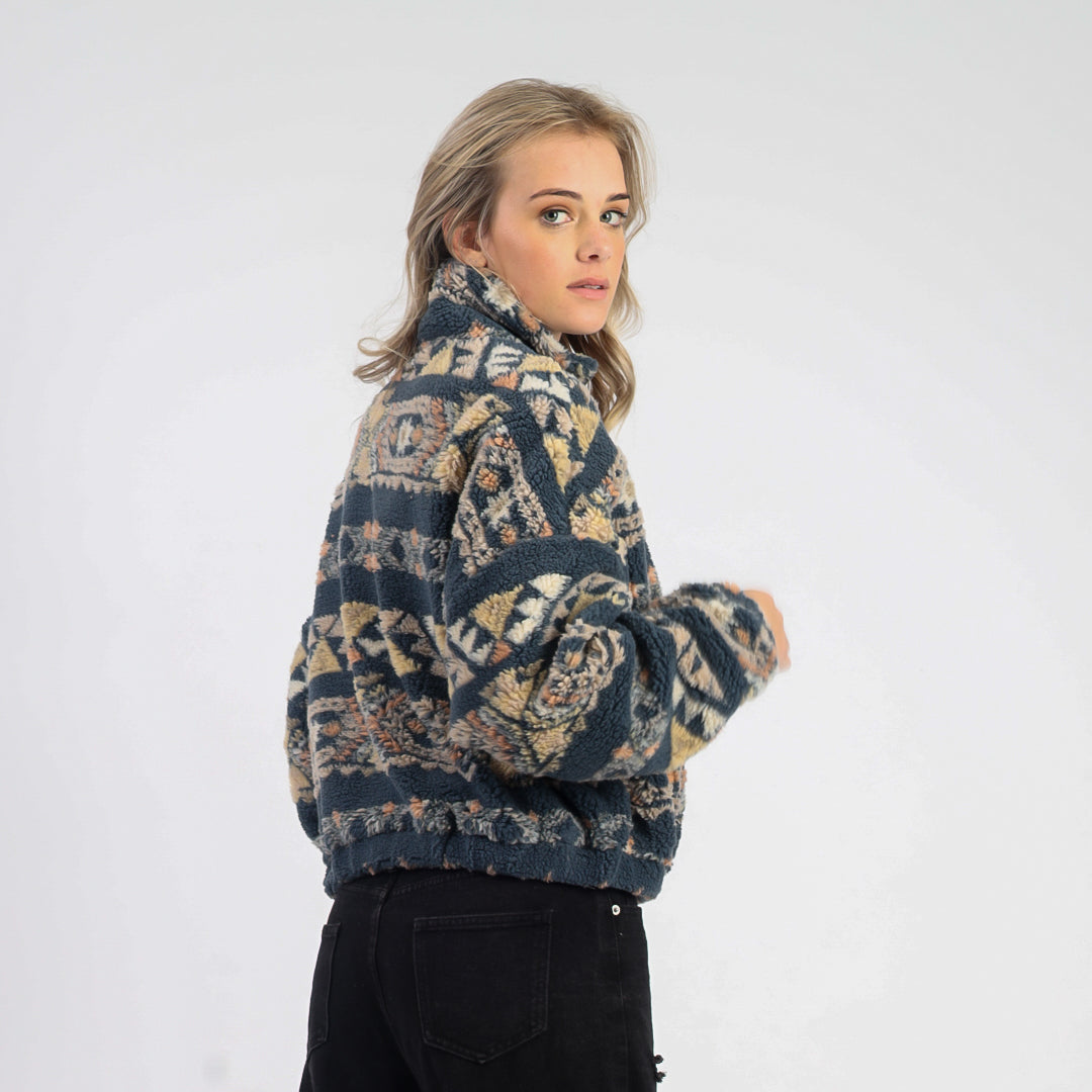 Woman wearing a patterned sweater against a white background