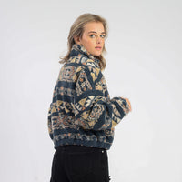 Woman wearing a patterned sweater against a white background