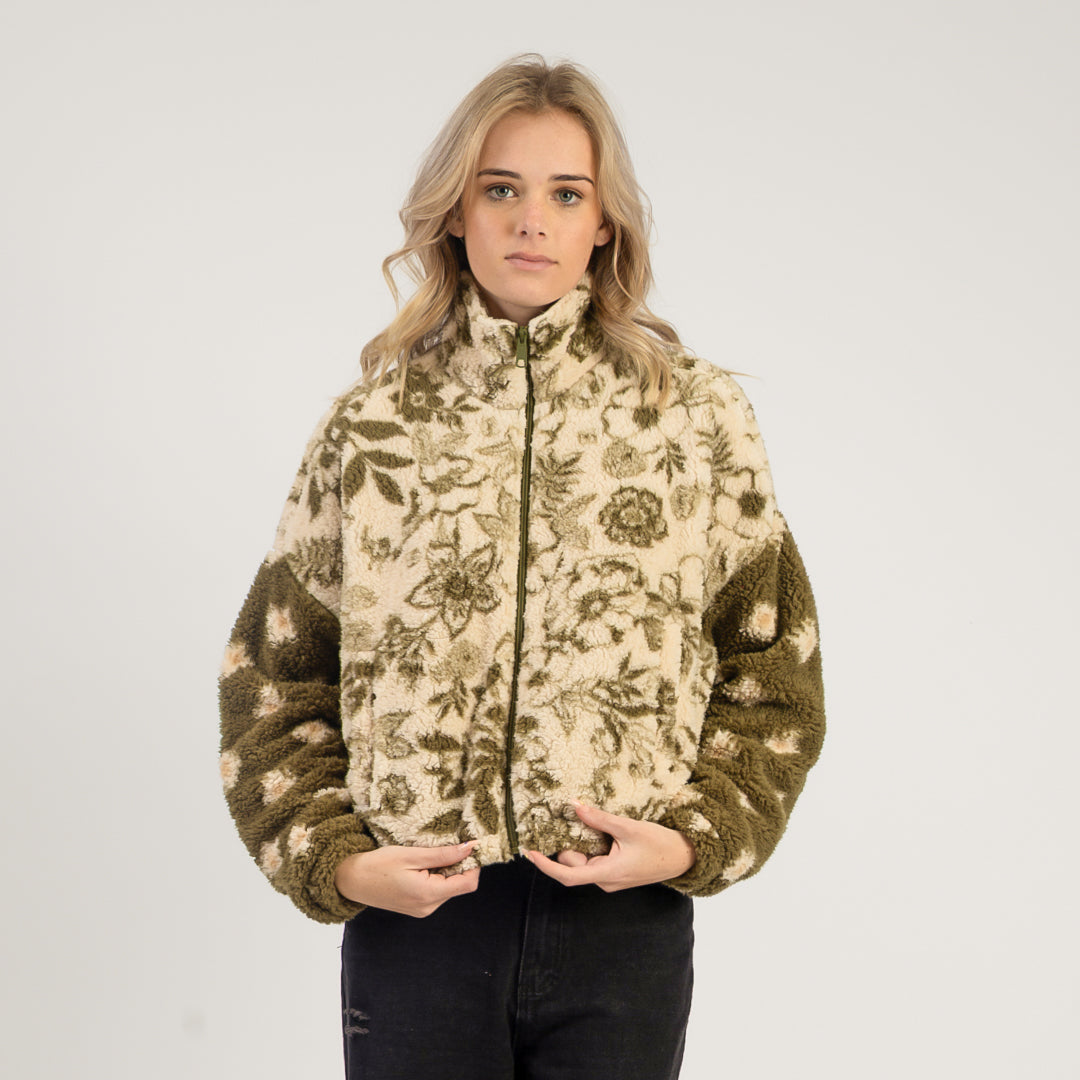 Woman wearing a floral patterned jacket on a plain background