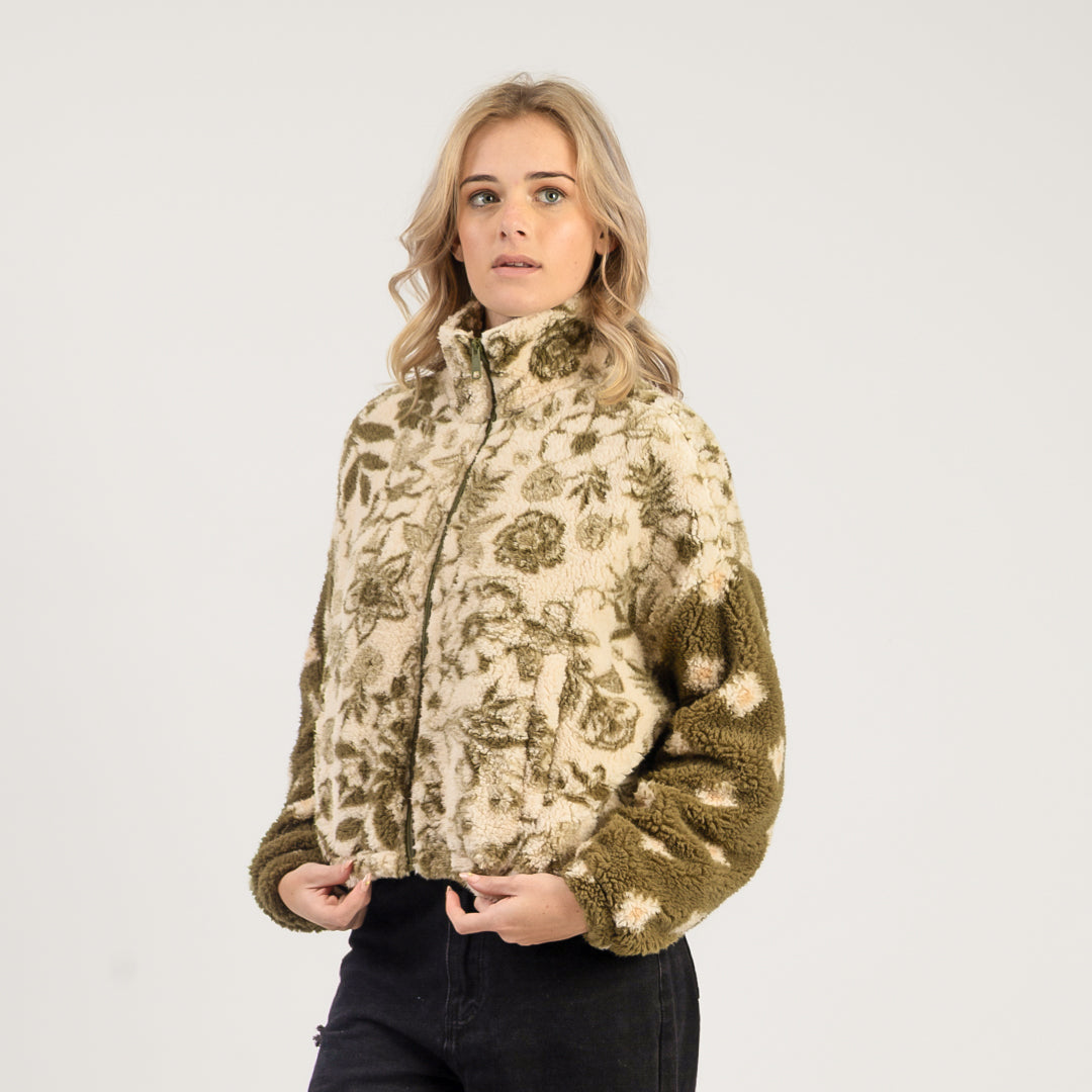 Woman wearing a floral patterned jacket on a white background