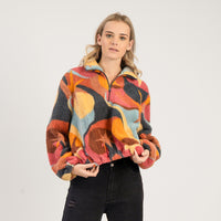 Woman wearing a colorful patterned jacket on a white background