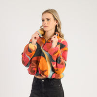 Woman wearing a colorful patterned sweater against a white background