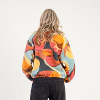 Person wearing a colorful patterned jacket on a white background