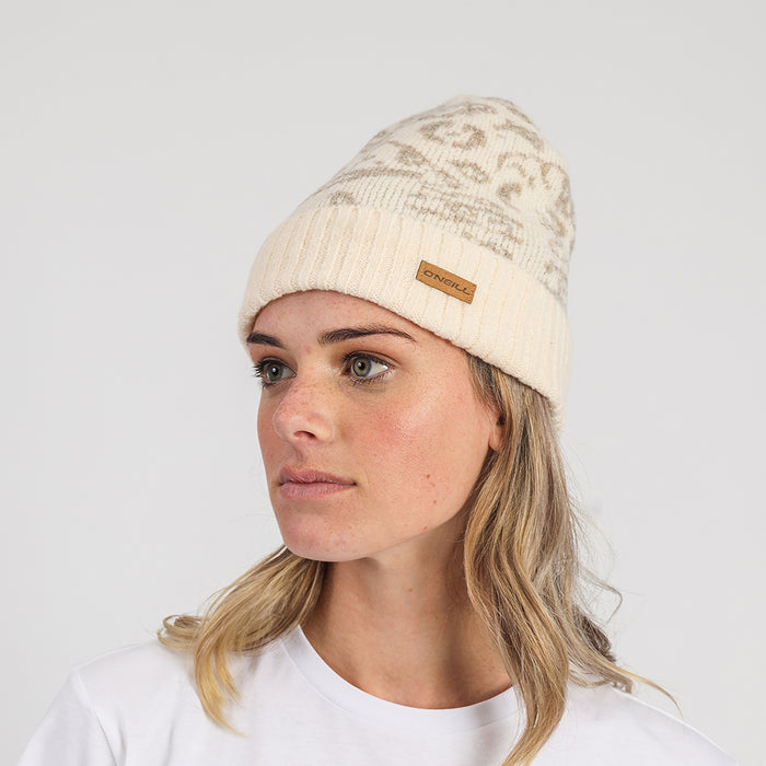 Woman wearing a beige beanie with a brand logo on a white background