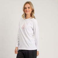 Woman wearing a white long-sleeve shirt with a logo on a plain background