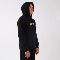 Person wearing a black hoodie with a logo on a white background