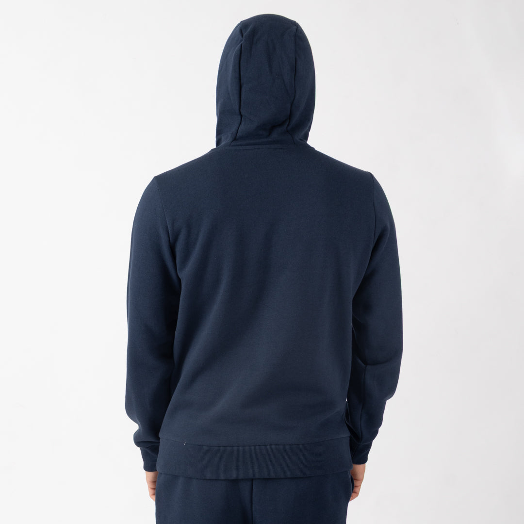 Person wearing a navy blue hoodie and pants on a white background