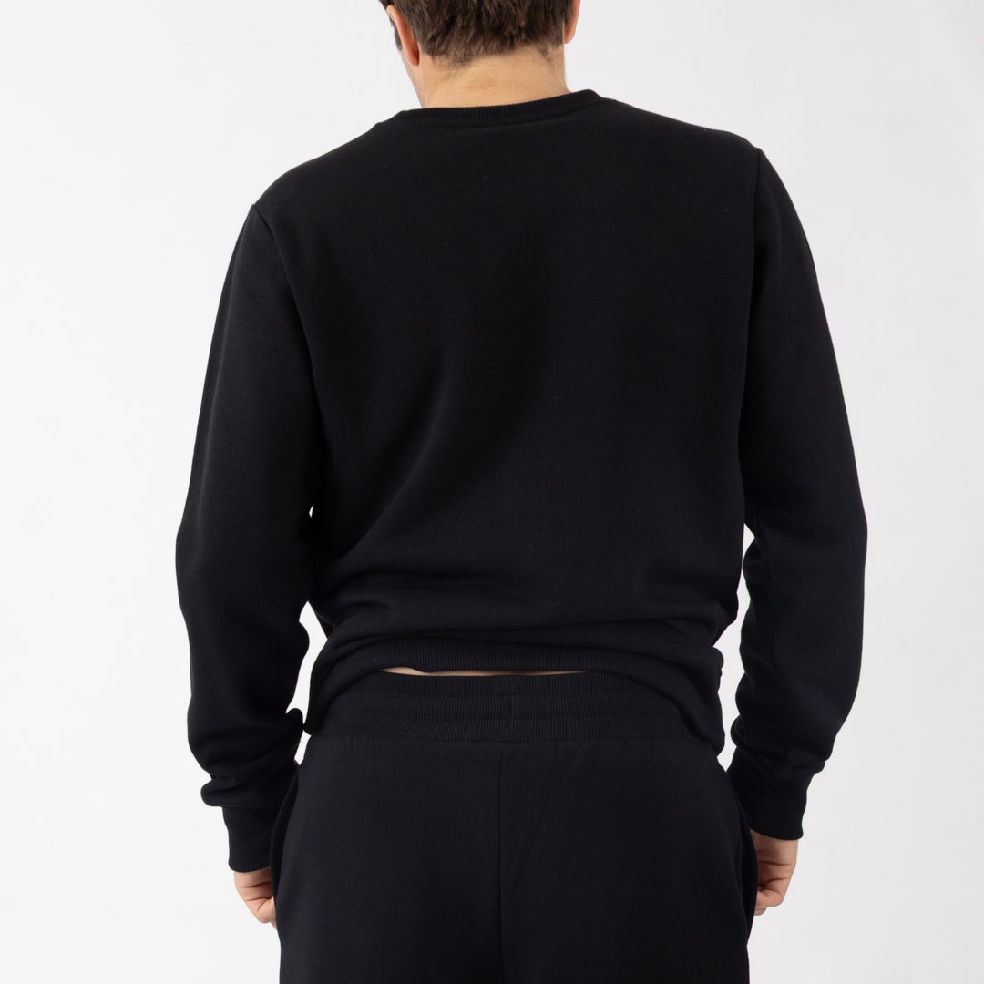 Person wearing a black sweatshirt and pants on a white background