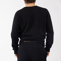Person wearing a black sweatshirt and pants on a white background