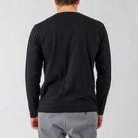 Person wearing a black long-sleeve shirt and gray pants on a light gray background