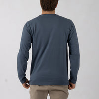 Person wearing a blue long-sleeve shirt against a white background