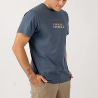 Man wearing a blue O'Neill t-shirt on a light gray background