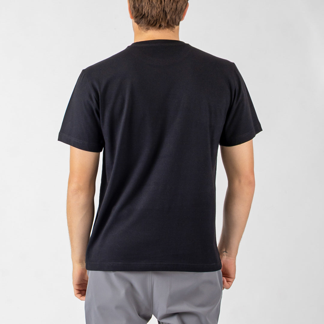 Person wearing a black t-shirt and gray shorts on a light gray background