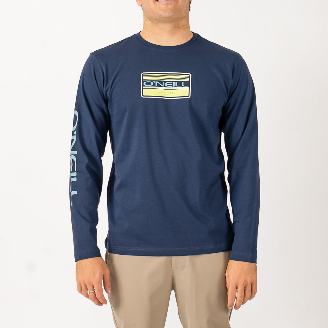 Man wearing a navy long-sleeve shirt with a logo on a white background