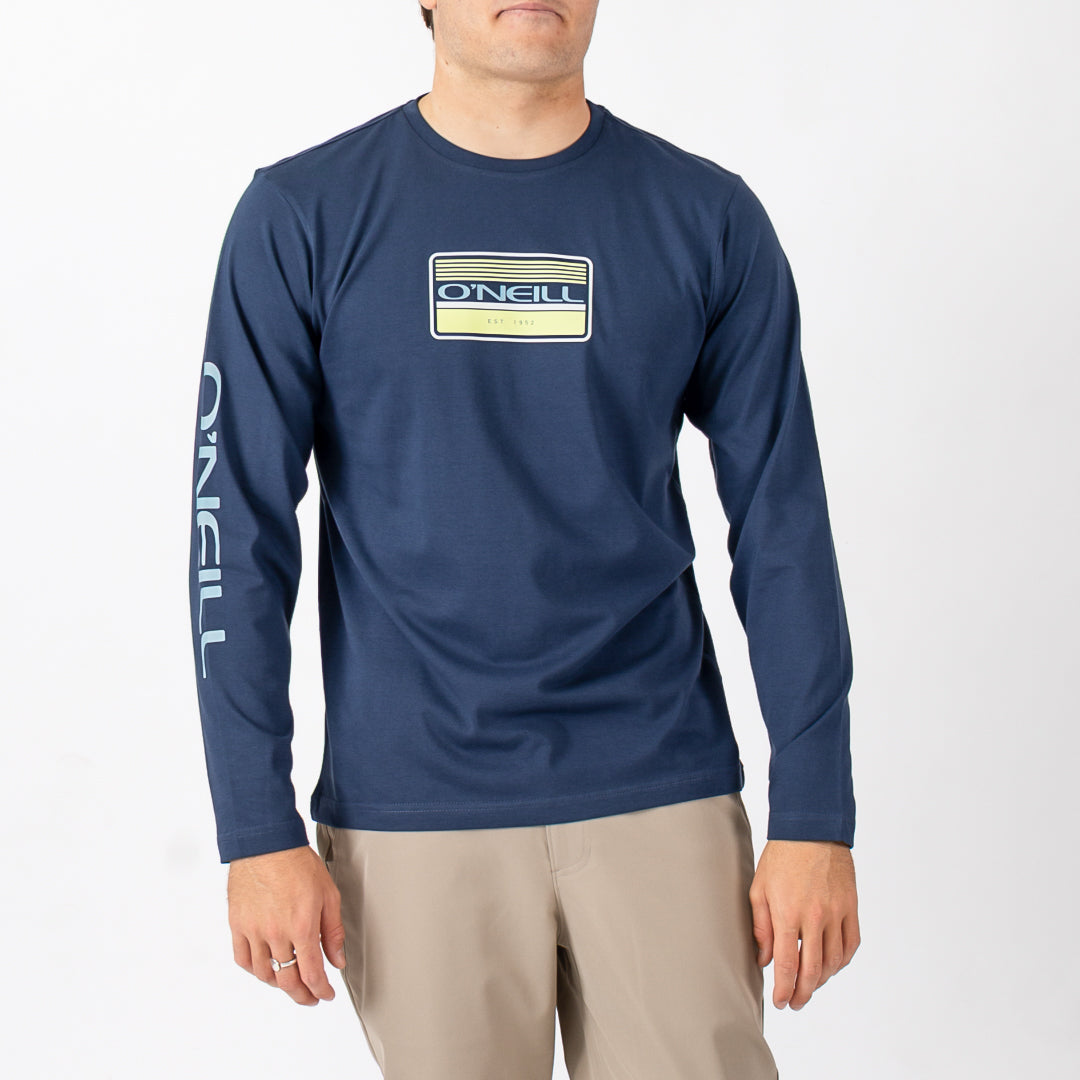 Man wearing a navy long-sleeve shirt with a logo on a white background
