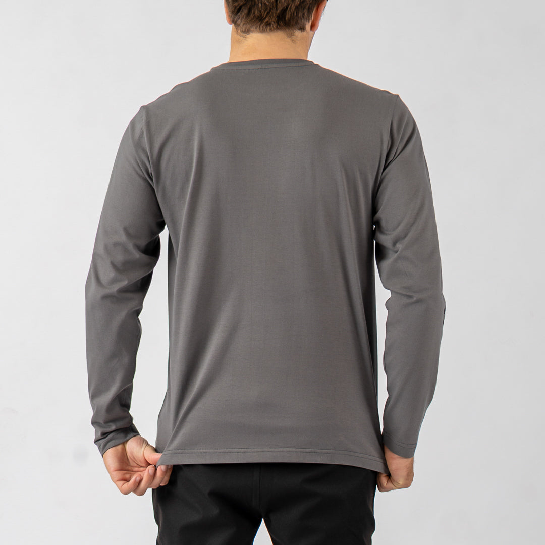Person wearing a gray long-sleeve shirt against a white background