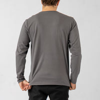 Person wearing a gray long-sleeve shirt against a white background