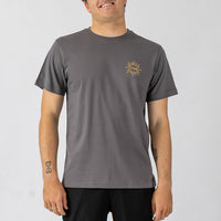 Person wearing a gray t-shirt with a logo on a plain background
