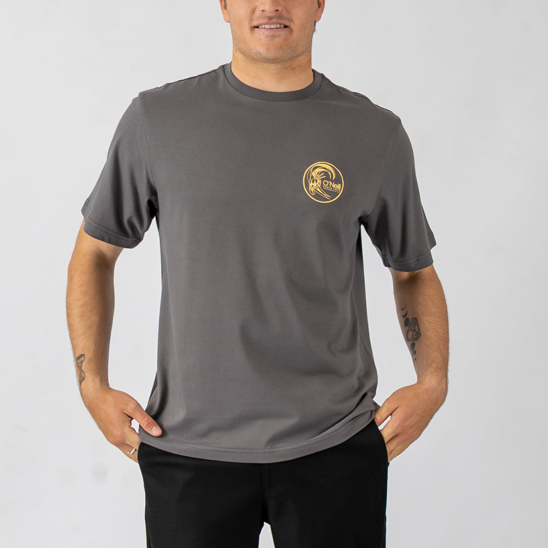 Man wearing a gray t-shirt with a yellow logo on a plain background
